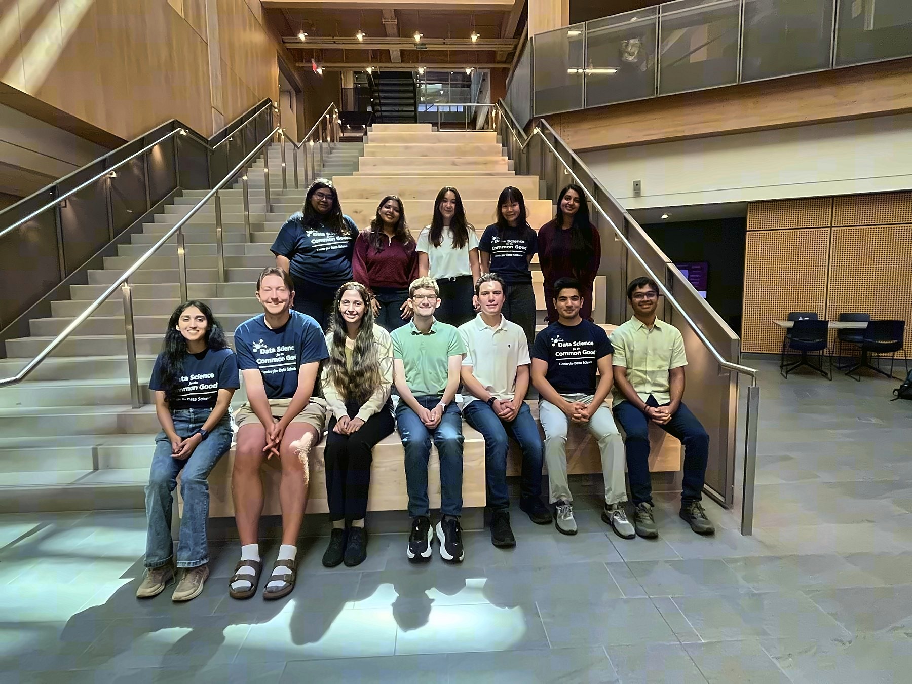 The Data Science for the Common Good cohort seated on the atrium stairs