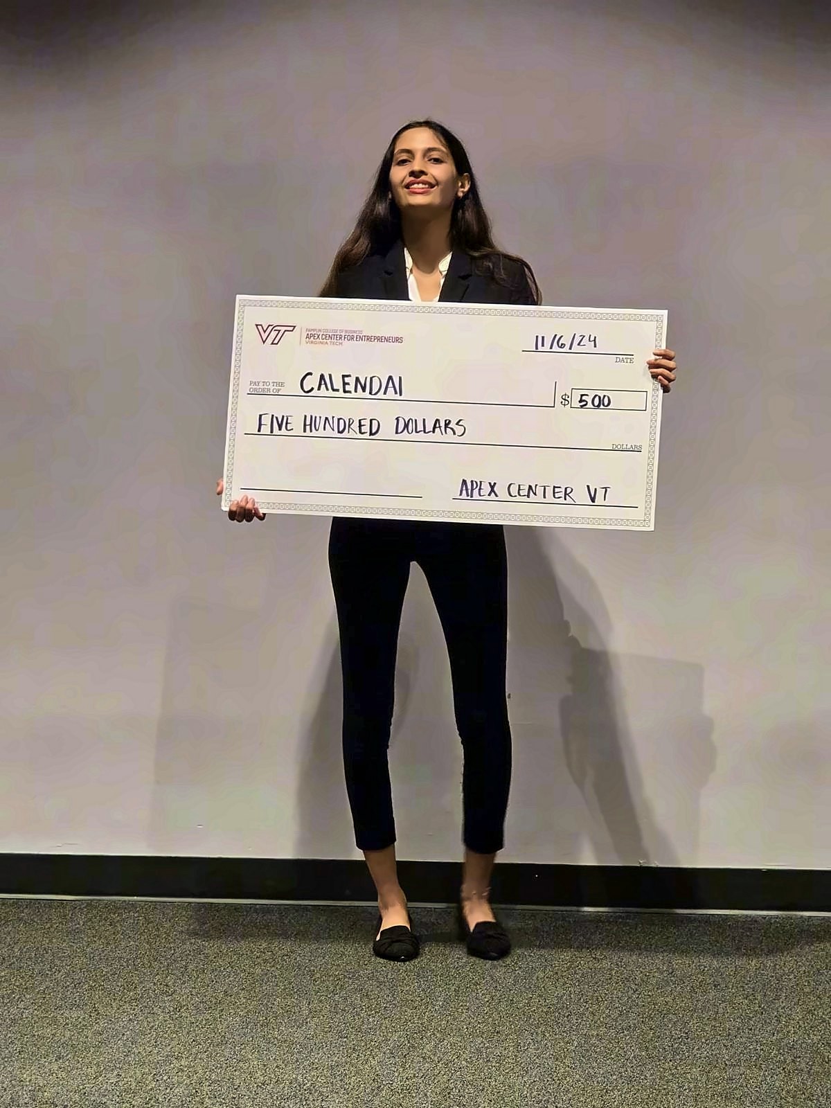 Kinjal Pandey holding a $500 presentation cheque awarded to CalendAI by the Apex Center for Entrepreneurs at Virginia Tech